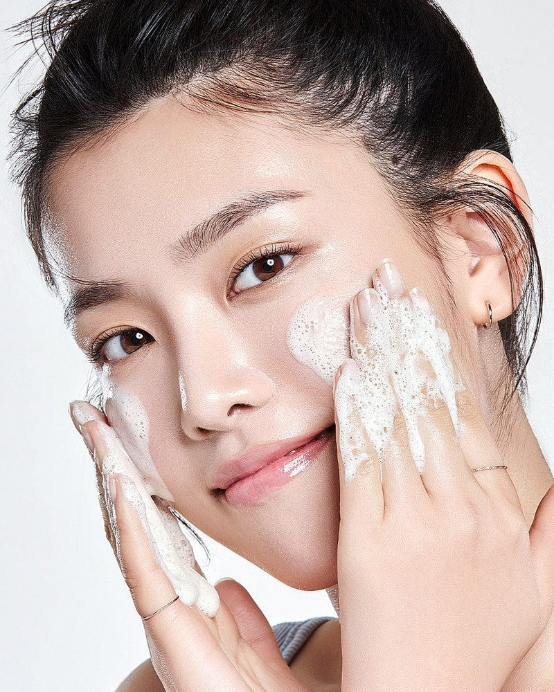 Anua 8 Hyaluronic Acid Hydrating Gentle Foaming Cleanser bottle with foam on hand, showcasing moisturizing Korean skincare cleanser.