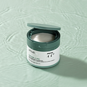 Anua Heartleaf 77 Clear Pad container with toner-soaked exfoliating pads, ideal for Korean skincare routines targeting sensitive or oily skin.