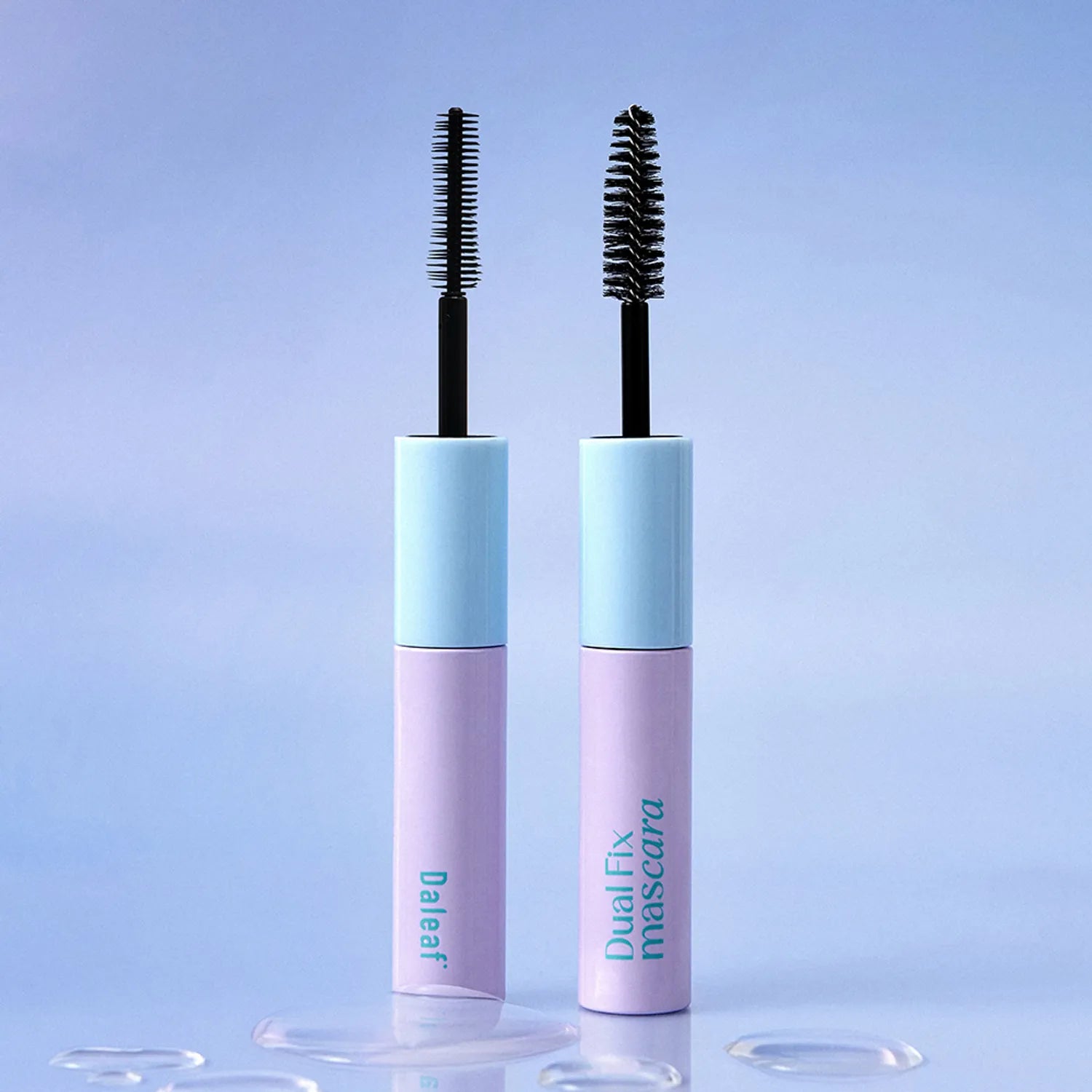 Two mascara tubes with blue and pink packaging on a light blue background