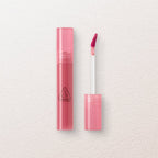Pink lip gloss with case on a light beige background